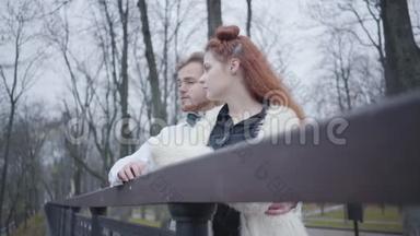 一对迷人的白种人夫妇站在桥边聊天。 秋天公园的时尚<strong>男女约会</strong>